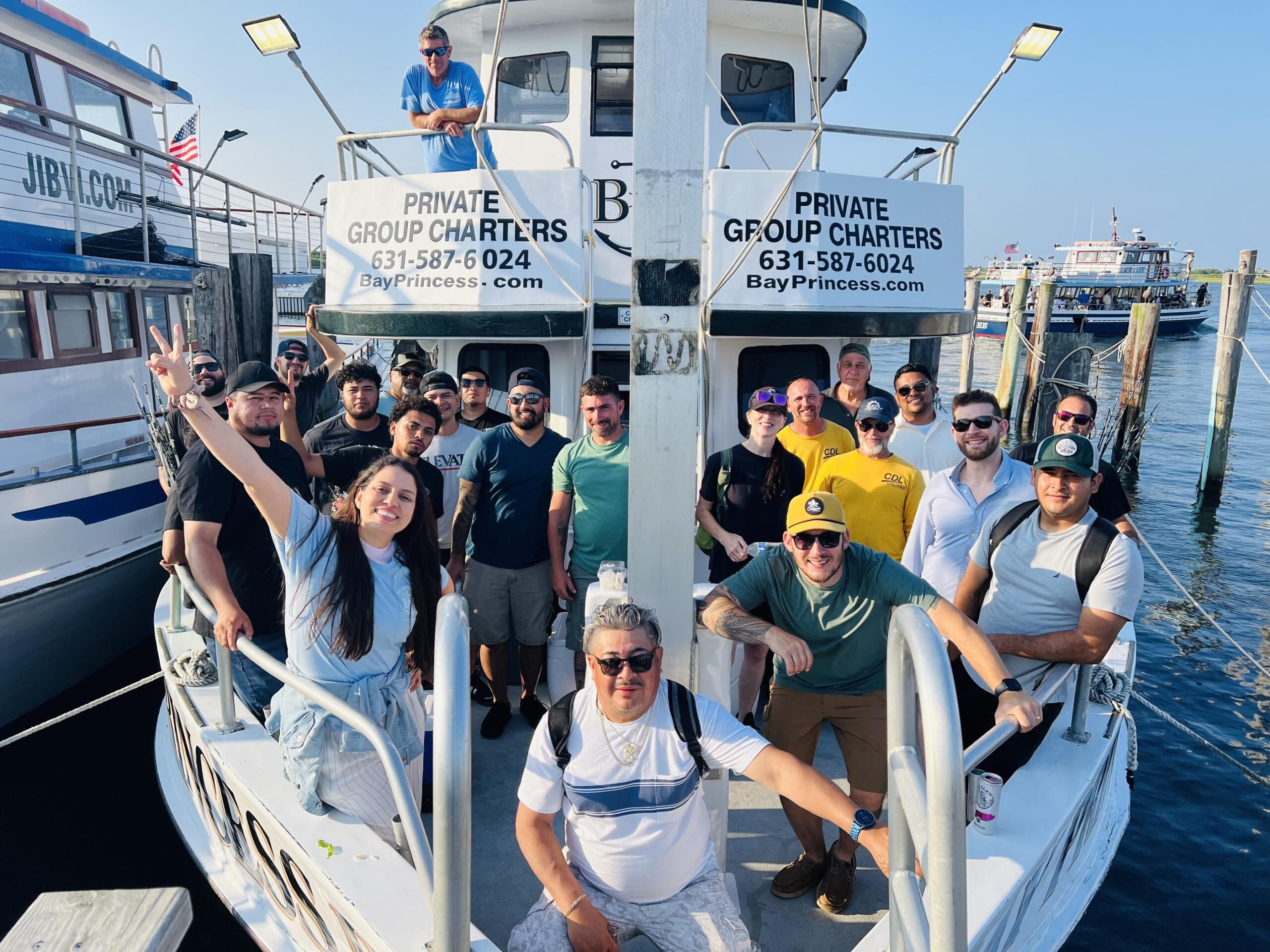 Large group photo on the deck of a charter boat taken at the dock.